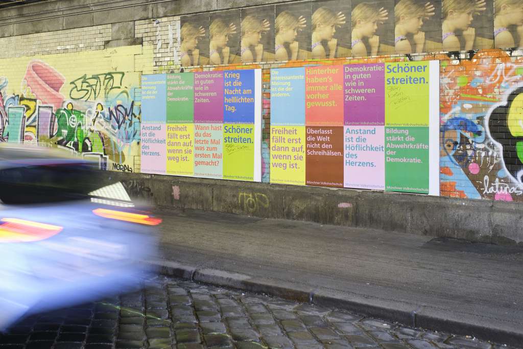 Die Plakate der Kampagne auf einer Plakatwand in München